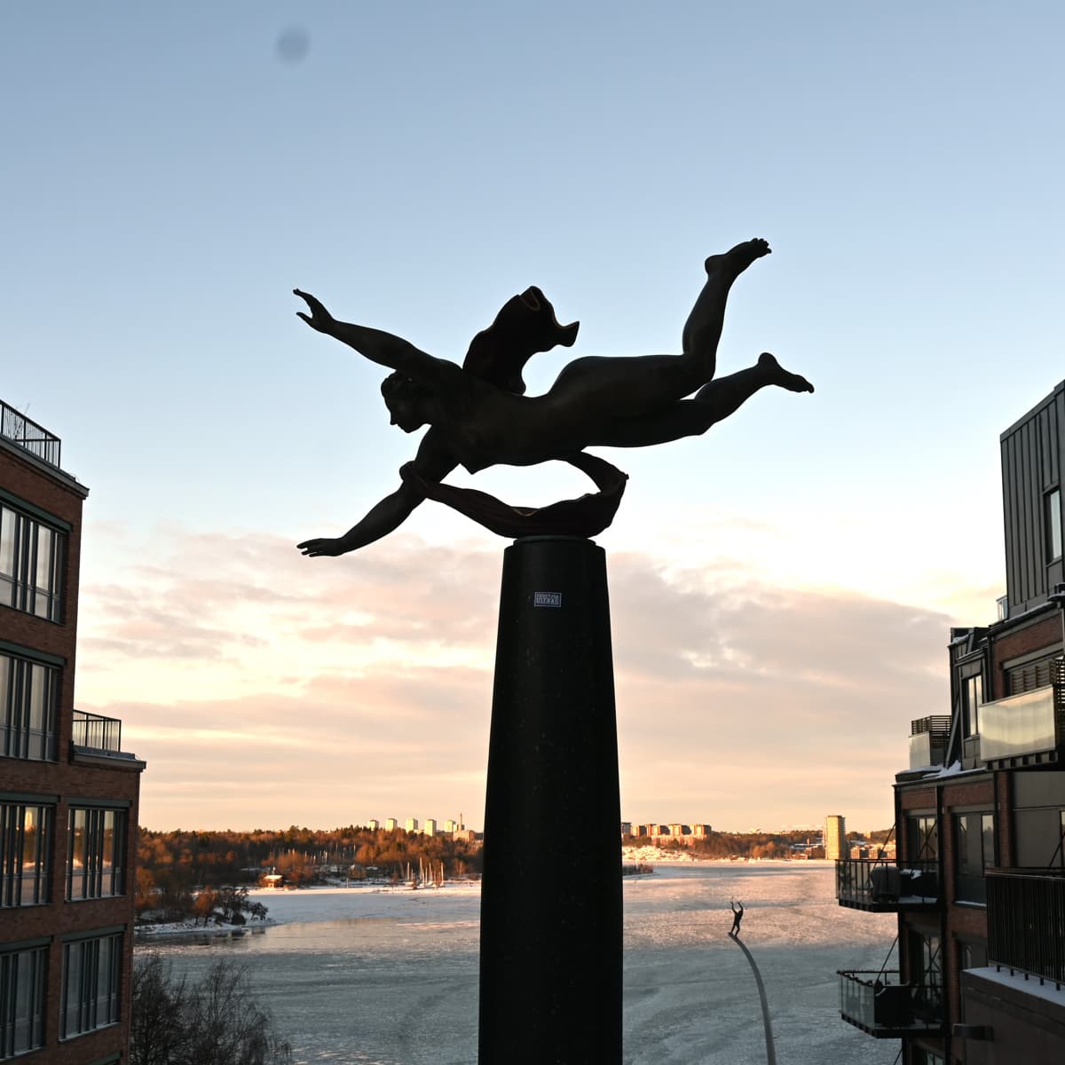 En staty på en stolpe framför en sjö
