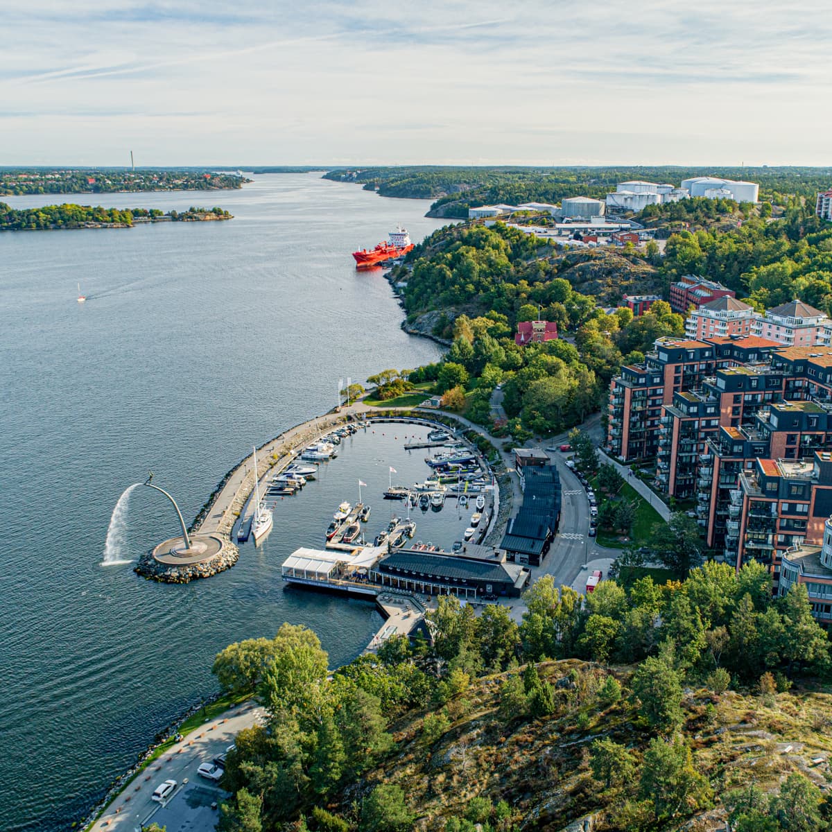 En stor vattenyta omgiven av träd och byggnader.